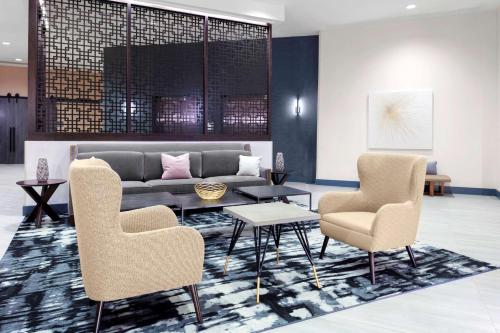 a lobby with a couch and two chairs and a table at Hyatt House Charlotte Rea Farms in Charlotte
