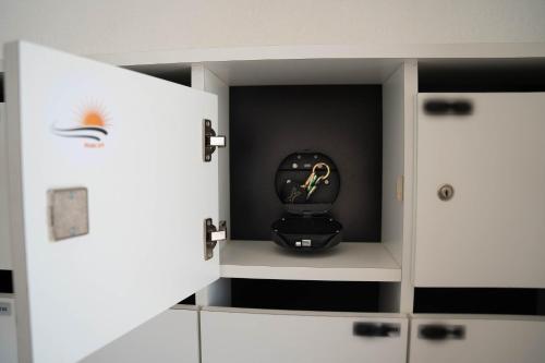 a kitchen with white cabinets and a black appliance at Rising Sun Westende in Middelkerke