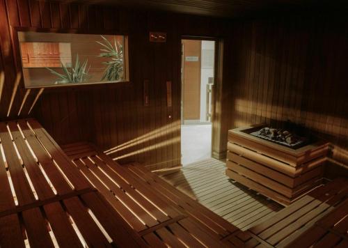 Cette chambre en bois dispose d'un banc et d'une photo. dans l'établissement Hotel Arena Maribor, à Maribor