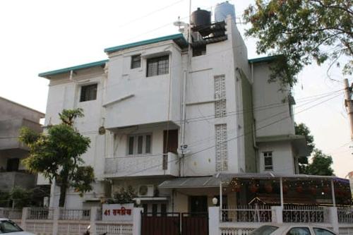 ナーグプルにあるRampriya Service Apartmentの正面に看板がある大きな白い建物