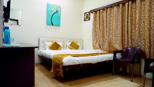 ein Schlafzimmer mit einem Bett, einem Tisch und einem Stuhl in der Unterkunft Rampriya Service Apartment in Nagpur