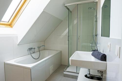een badkamer met een douche, een wastafel en een bad bij Vienna Living Apartments - Hadrawagasse in Wenen
