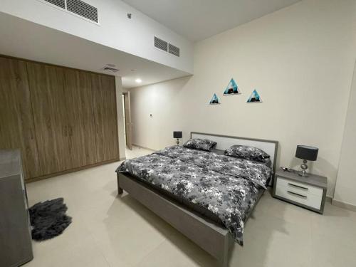 a bedroom with a bed and a night stand in it at Lovely New 1 bed Apt - Mirdif Hills Avenue in Dubai