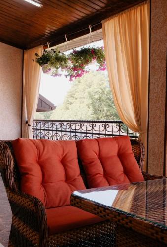 a couch sitting next to a table and a window at Готель Хутір in Malyye Khutora