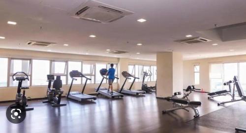 a gym with treadmills and exercise bikes in a room at Shah Alam Tokma Servis Apartment in Shah Alam