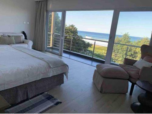 a bedroom with a bed and a view of the ocean at Splash Rock Beachfront Villa in Umtentweni