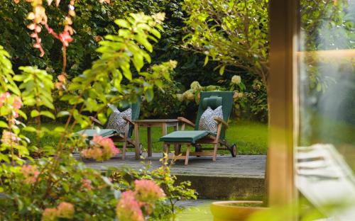 two chairs and a table in a garden at Hotel Gasthof Brandstätter in Salzburg