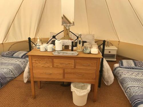 een kamer met een tafel, 2 bedden en een tent bij Cox Hill Glamping Badger in Truro