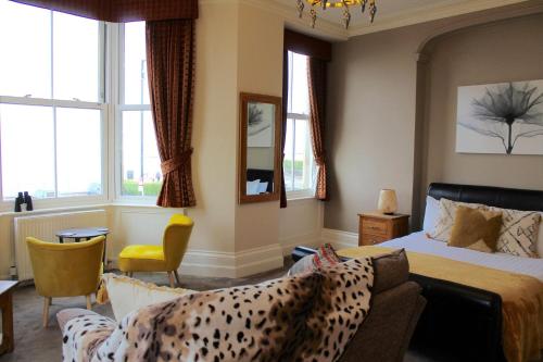 a bedroom with a bed and a couch and windows at The Crown Hotel in Morecambe