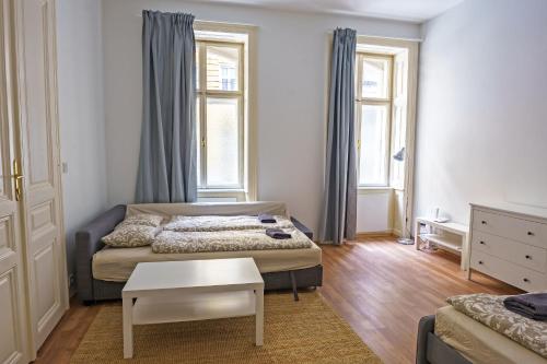 Kleines Zimmer mit 2 Betten und einem Tisch in der Unterkunft Vienna Living Apartments - Müllnergasse in Wien