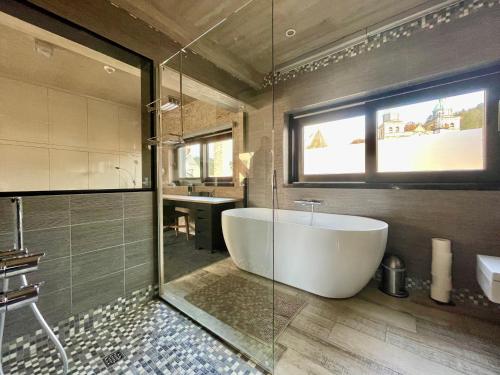 ein Badezimmer mit einer großen Badewanne und einem Waschbecken in der Unterkunft Guesthouse ROOM40 in Malmedy