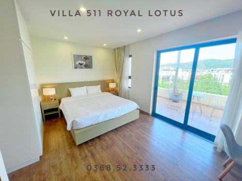 um quarto com uma cama e uma porta de vidro deslizante em Chuỗi Villa 5 Phòng Ngủ Căn 410-409-308 Royal Lotus Hạ Long em Ha Long