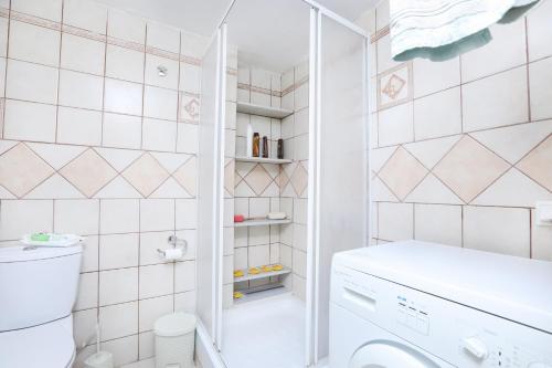 a small bathroom with a toilet and a washer at Platouka's House in Ágios Matthaíos