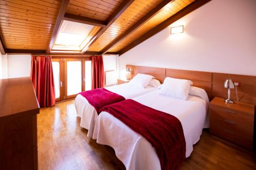 1 Schlafzimmer mit 2 Betten und einem Fenster in der Unterkunft Apartamentos Cean Bermudez in Gijón