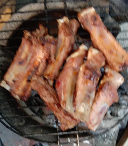 a bunch of bacon cooking on a grill at Bunyong Homestay in Siem Reap