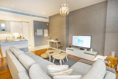 FAM Living City Walk - Opposite City Walk Mall - 2A في دبي: غرفة معيشة مع أريكة وتلفزيون