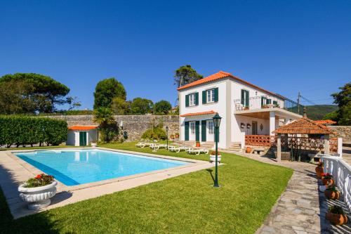 a villa with a swimming pool and a house at CASA BACELAR in Afife
