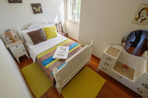 a small bedroom with a white bed and a crib at CASA BACELAR in Afife