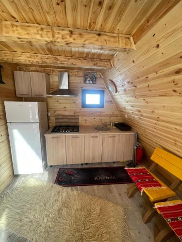 a small kitchen in a log cabin with a refrigerator at Aroa Mountain 4 in Zărneşti