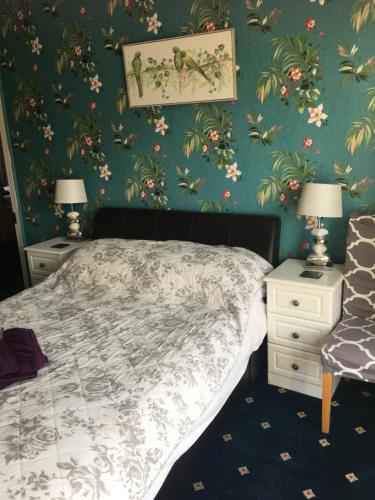 a bedroom with a bed and two night stands with lamps at Hillcrest Guest House in Llangollen