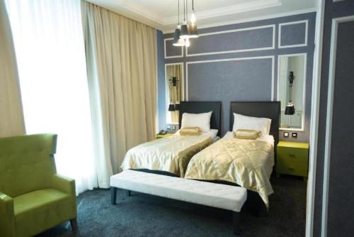 a bedroom with a bed and a chair in it at Dondar Hotel Formula 1 View in Baku