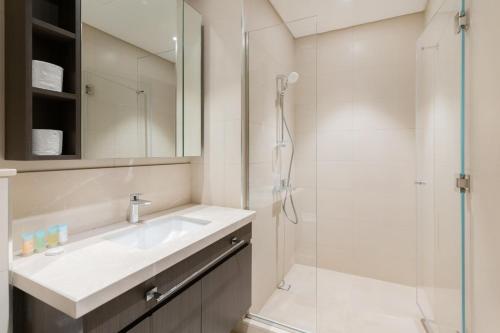 uma casa de banho com um lavatório e um chuveiro em Luxury I Free Weekly Housekeeping I 5 Mins to Dubai Mall no Dubai