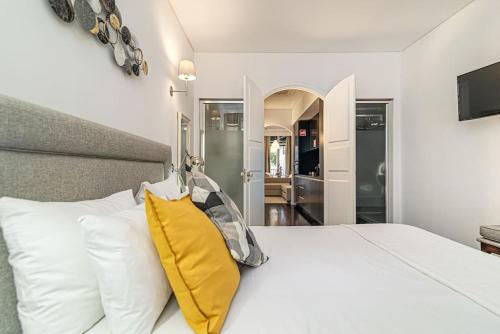 een slaapkamer met een wit bed en een geel kussen bij Sandeman's Apartment by Innkeeper in Vila Nova de Gaia
