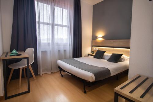 a hotel room with a bed and a window at Alda Puerto Seco in Burgos