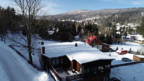 uma casa coberta de neve ao lado de uma estrada em Apartament Karamba em Szklarska Poręba