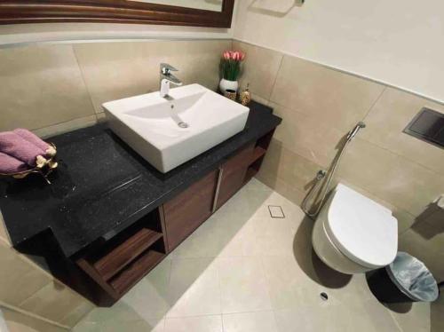 a bathroom with a sink and a toilet at Luxurious 1 bed Apt with Outdoor Patio - Madinat Badr in Dubai