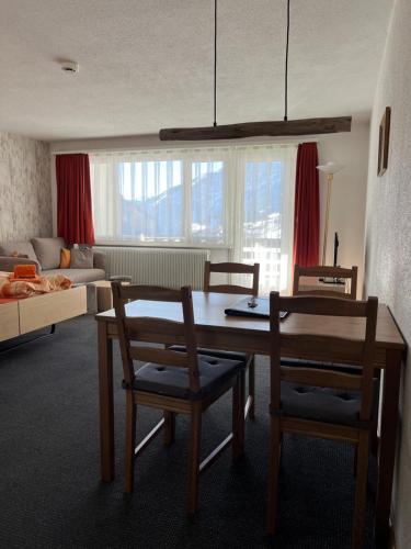 uma sala de estar com uma mesa e duas cadeiras em Haus Atlantic Leukerbad em Leukerbad