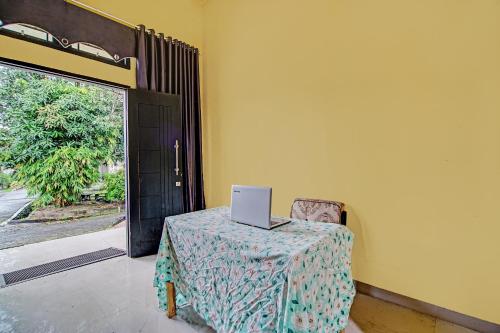 una mesa con un ordenador portátil sentada junto a una puerta en OYO 92177 Arafah Homestay Syariah en Bangkinang