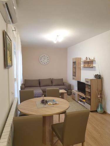 a living room with a table and a couch at Apartman SAN in Vukovar