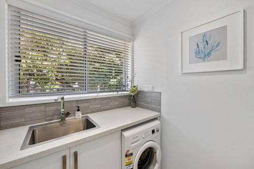 a kitchen with a sink and a washing machine at 5 min walk to Four Pillars! in Healesville