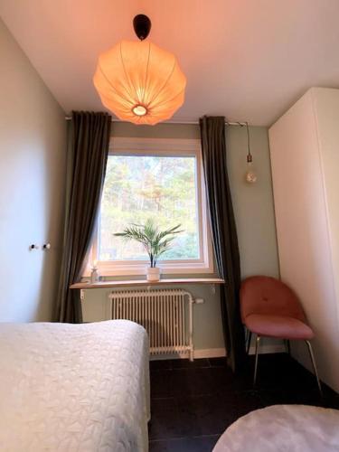 a bedroom with a bed and a window and a chair at Aekta Studio apartments Gothenburg in Gothenburg