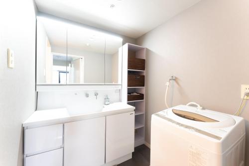 a white bathroom with a sink and a mirror at VIVI熱海 自然郷 3001丨VIVI Atami Shizenkyo 3001 in Atami