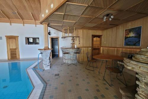 uma sala de estar com uma piscina, uma mesa e uma mesa em Pinecrest Villa - Castle style living on seaside em Porvoo