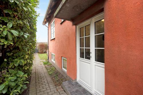 a red brick building with a white garage door at Charm 2 - Great 2-Bdr Apt with Shared Garden and Balcony in Copenhagen