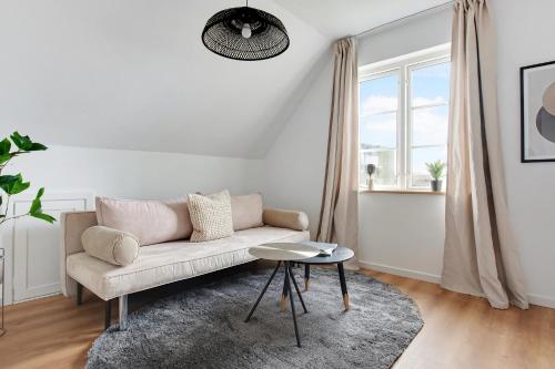 a white living room with a couch and a table at Charm 2 - Great 2-Bdr Apt with Shared Garden and Balcony in Copenhagen