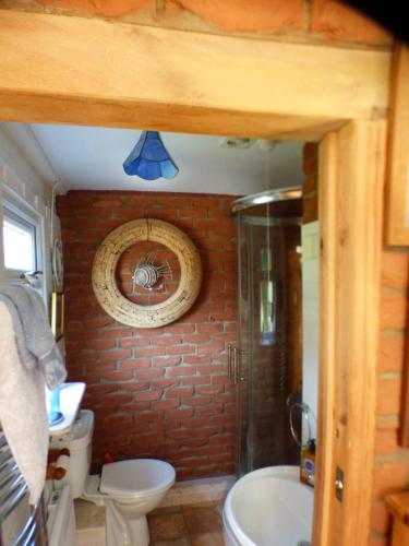 uma casa de banho com um chuveiro, um WC e um lavatório. em NELSONS CABIN em North Creake
