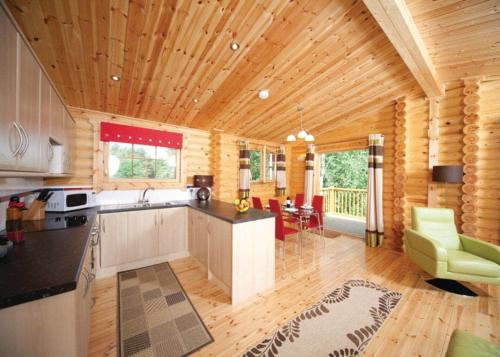 a kitchen with wooden walls and a wooden ceiling at Langmere Lakes Lodges in Hainford
