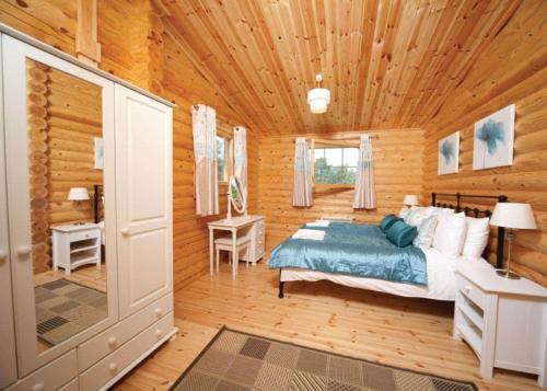 a bedroom with a bed and a wooden ceiling at Langmere Lakes Lodges in Hainford