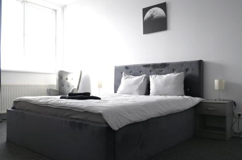 um quarto preto e branco com uma cama grande em Luana Airport Apartments #8 em Otopeni