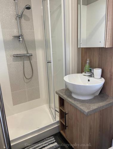 a bathroom with a white sink and a shower at 18 Duckpool in Kilkhampton