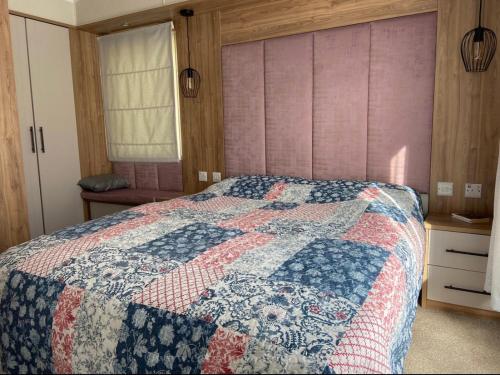 a bedroom with a bed with a quilt on it at 18 Duckpool in Kilkhampton