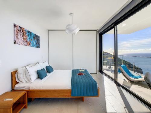 een slaapkamer met een bed en uitzicht op de oceaan bij Francelho 1 Apartment by LovelyStay in Ribeira Brava