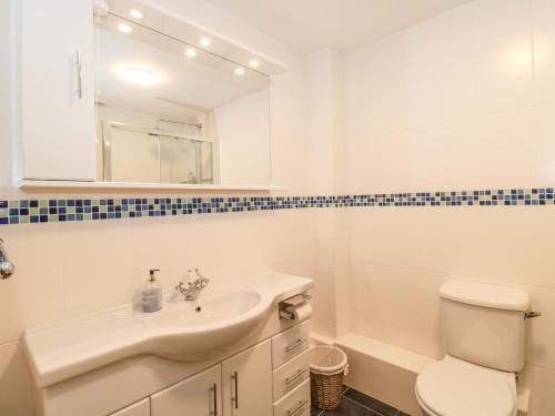 a white bathroom with a sink and a toilet at Rainbow View in Taunton