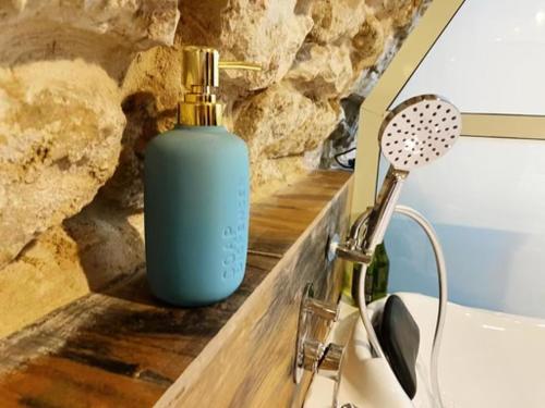 a blue bottle of soap sitting next to a sink at Tzfat Boutique Stay! in Safed