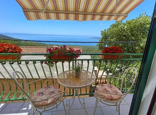 a table and chairs on a balcony with a view at Holiday House Terezija in Baška Voda