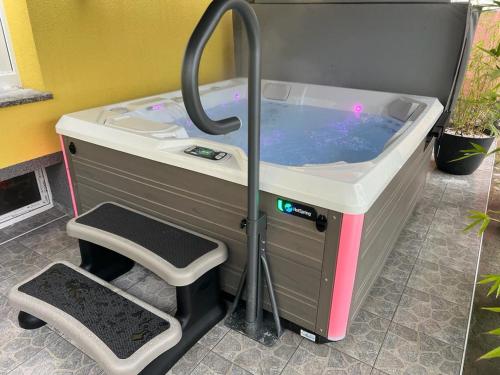 a hot tub with a stool next to at La Luna Rustic Deluxe Apartment with Free Jacuzzi, Bikes & Covered Parking in Našice